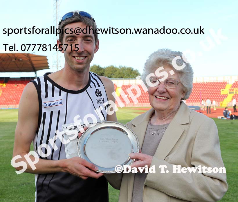 Jonathan Cook (Woodford Green)  receives the Stan Long Mile Trophy from Joan Long (Stan Long's widow), North East Grand Prix, Gateshead International Stadium. Photo: David T. Hewitson/Sports for All Pics